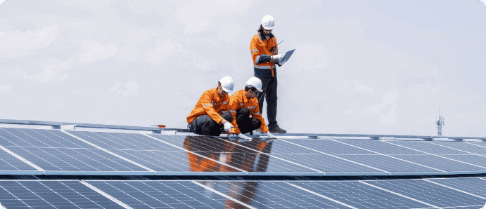Workers installing solar panels on a commercial building rooftop.
