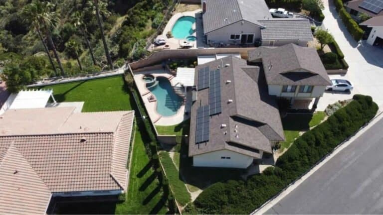 Aerial view of a house with solar panels installed on the roof.