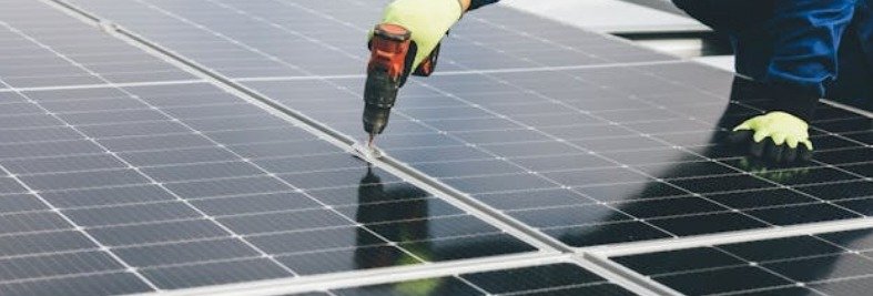 Worker installing solar panels on a rooftop.