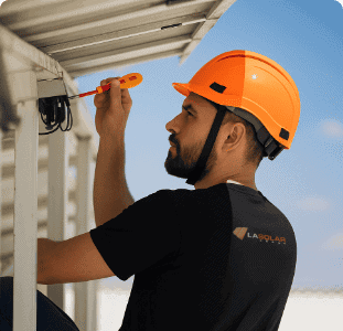 Solar technician checking electrical panel with screwdriver.