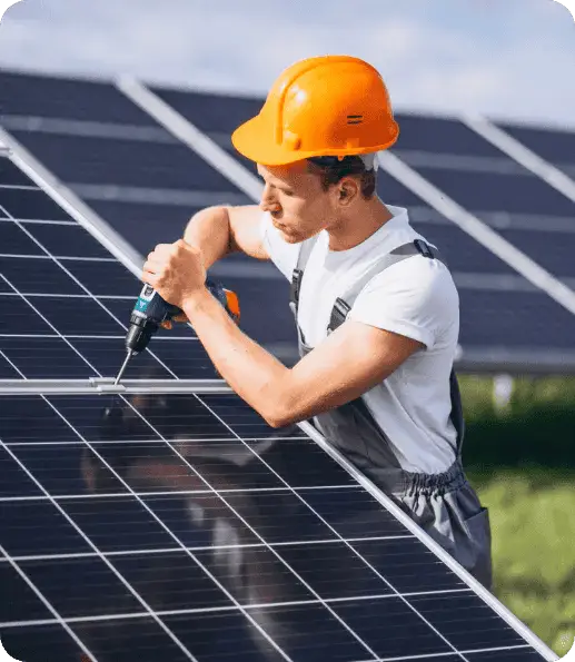 Solar technician working on solar panels with a drill in a solar farm.