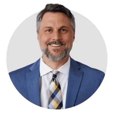 Professional man in a blue suit smiling, representing LA Solar Group's expertise.