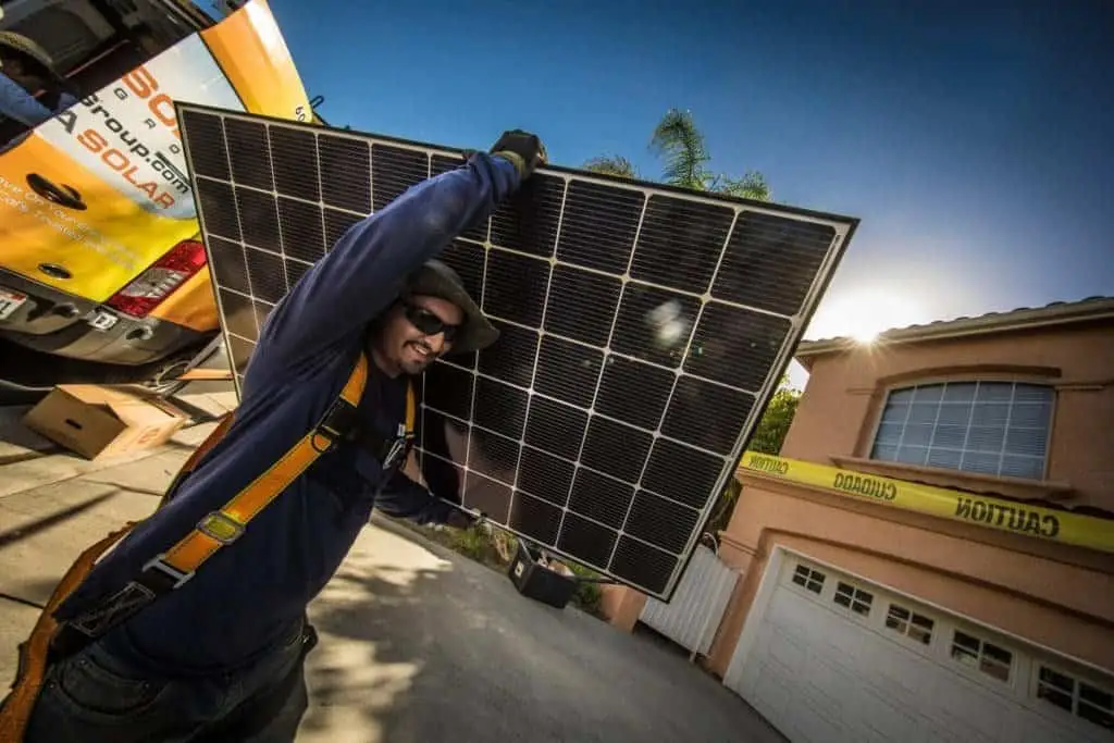 Solar panel technician installing a solar energy system on a sunny day.