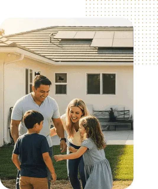 Family enjoying sunny day outside a house with solar panels on the roof.