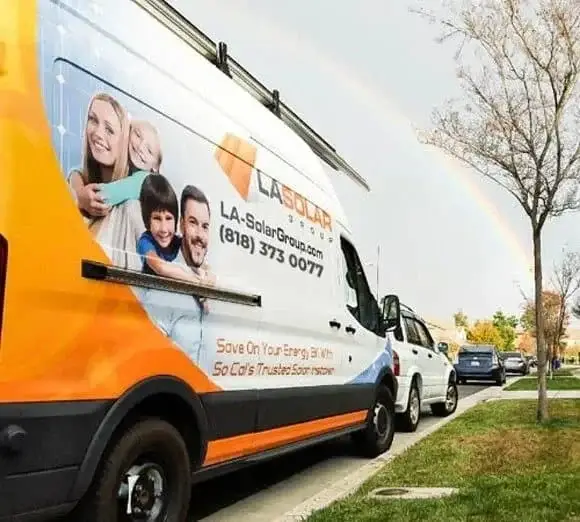 LA Solar Group delivery van parked on the street with family image and company branding.